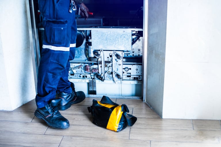 Técnico reparando sistema de elevación en edificio industrial