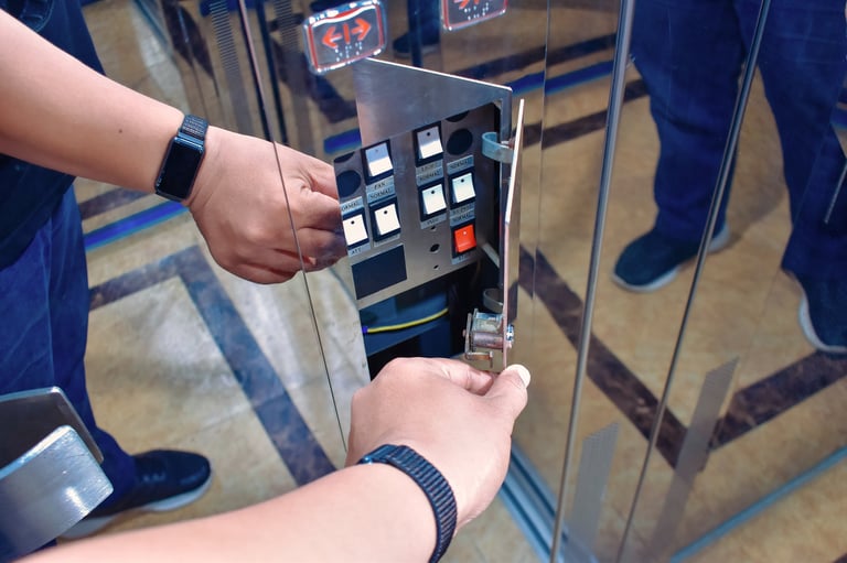 Técnico reparando panel de control eléctrico de elevador