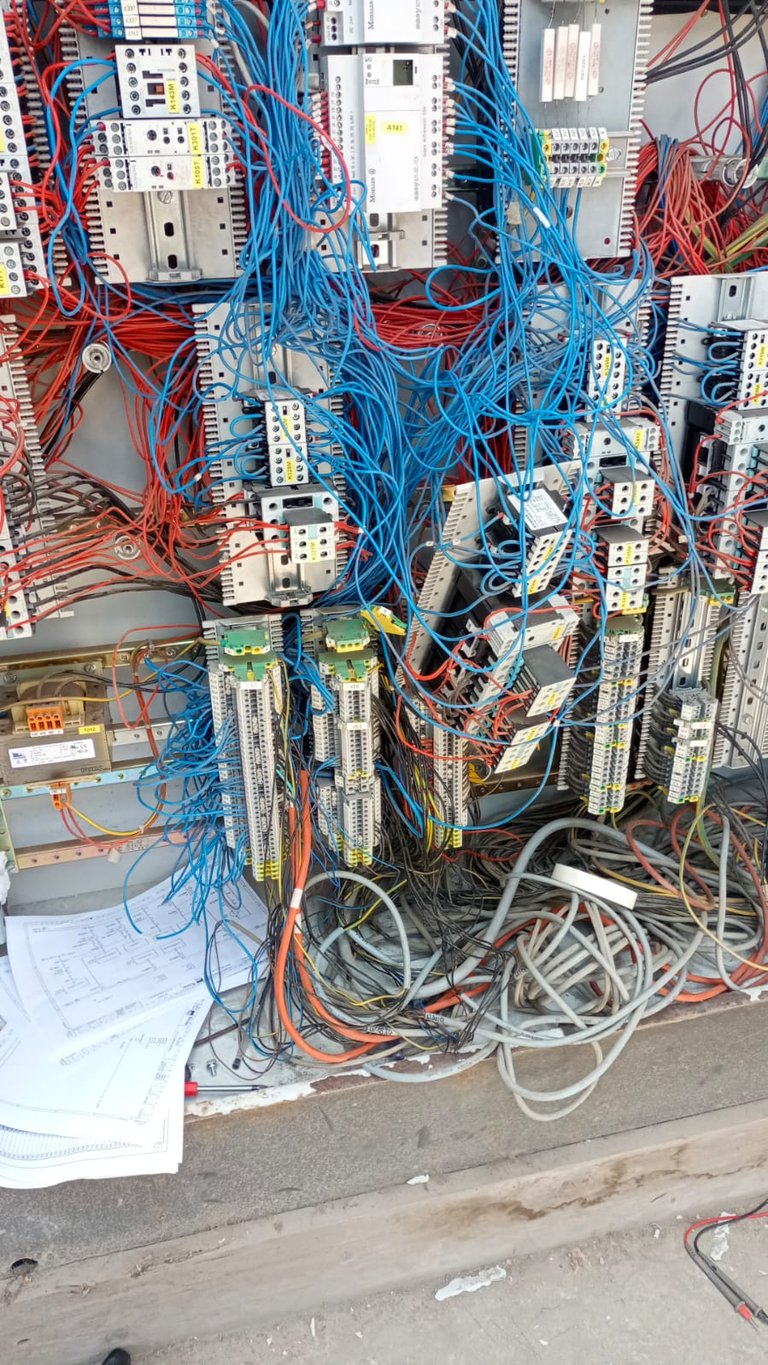 Complex electrical installation with colored wires, circuit boards, and terminal blocks mounted on wall panels